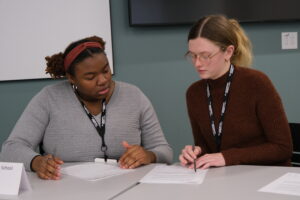 Image of Roger Bacon team members deliberate before responding in preliminary