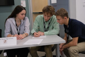 Image of Roger Bacon team members deliberate before responding in preliminary