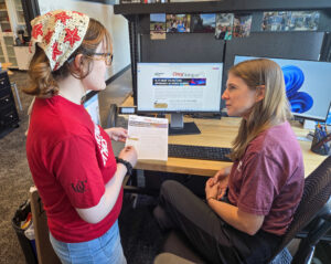 Gwen Schumann with Christina Baulch discussing an explainer article.